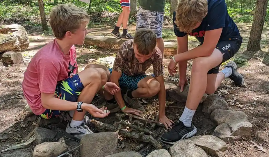 Participants from youth camp gathered around a fire pit